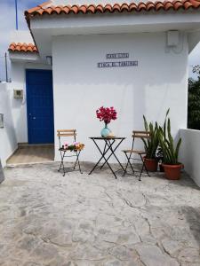 een patio met 2 stoelen en een tafel met bloemen erop bij Casa Lita in Hermigua