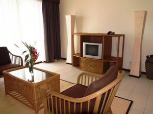 a living room with a couch and a tv and a table at Solomon Kitano Mendana Hotel in Honiara