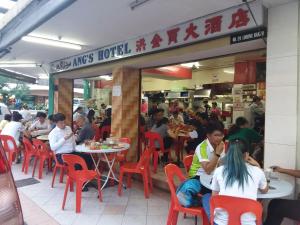 un grupo de personas sentadas en mesas en un restaurante en Hotel Tourist City Centre by HotSpot Essential, en Kota Kinabalu