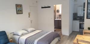 1 dormitorio pequeño con 1 cama y cocina en Inobello proche Chateau Chantilly Parc Asterix, en Vineuil-Saint-Firmin