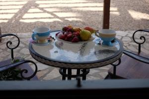 un bol de fruta en una mesa con dos tazas en Agriturismo Podere Farnesiana, en Tarquinia