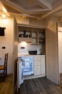 una cucina con armadietti bianchi e frigorifero di Affittacamere La Ferrata a San Michele allʼAdige