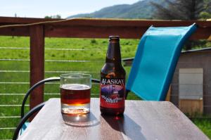 a bottle of beer sitting on a table with a glass at Homerhome in Homer