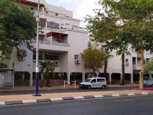 a white car parked in front of a building at Nelly's Housing Unit in Eilat