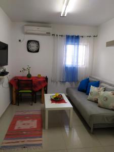 een woonkamer met een bank en een tafel bij Nelly's Housing Unit in Eilat