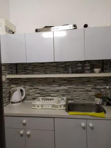 a kitchen counter with white cabinets and a sink at Nelly's Housing Unit in Eilat