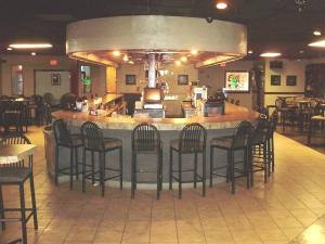 a bar in a restaurant with chairs around it at Trade Winds Central Inn in Tulsa
