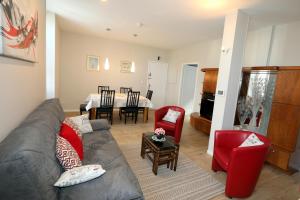 a living room with a gray couch and red chairs at Le Florès Idéalement situé Centre Luz Appart T3 6 personnes Parking in Luz-Saint-Sauveur