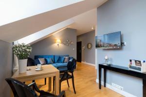 a living room with a blue couch and a table at Moon River Apartments Gdansk Old Town in Gdańsk