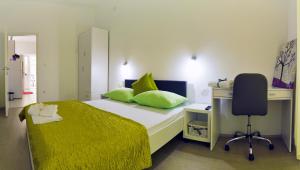 a bedroom with a bed with a desk and a chair at Firule Center Rooms in Split