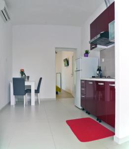 cocina con mesa y alfombra roja en Firule Center Rooms, en Split