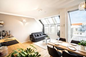 een woonkamer met een tafel en stoelen en een bank bij Boutique Design-Apartments Vienna in Wenen