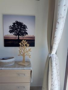 een kamer met een boomafbeelding en een gordijn bij GLI ALBERI apartment with view in Montepulciano