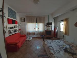a living room with a red couch and a bed at Casa Panorama Amalfi Coast in Vietri sul Mare