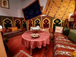 ein Wohnzimmer mit einem Tisch und einem Sofa in der Unterkunft Riad Ma Bohème in Meknès