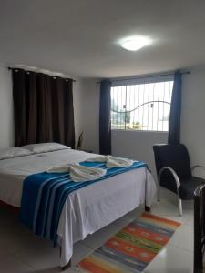1 dormitorio con 1 cama, 1 silla y 1 ventana en Residencial Fran Chiattone, en Natal