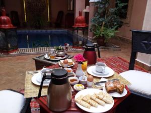 uma mesa com pratos de comida e bebidas sobre ela em Riad La Rose D'orient em Marraquexe