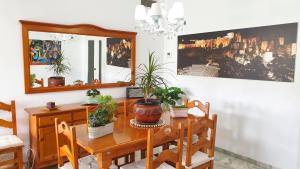 a dining room with a wooden table with plants on it at Golf Coast Los Alamos, Primera Linea de Playa in Torremolinos