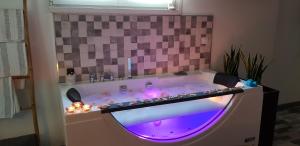 a bath tub with purple lights in a bathroom at El nido de la Galería in Setenil +31 photos