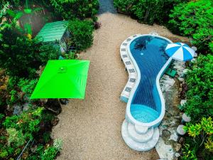 una vista aérea de una piscina con una mesa verde y una sombrilla en The Mouth Resort - SHA Extra Plus, en Khao Lak