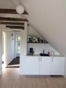 een keuken met witte kasten en een trap bij Lejlighed på landet, NO Smoking in Kvistgård