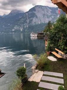 a boat on a lake with mountains in the background at Bootshaus am Hallstätter See in Hallstatt