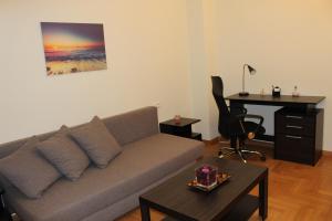 a living room with a couch and a desk at Comfortable apartment in the center of Athens in Athens