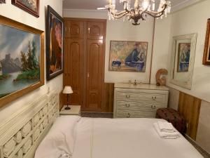 馬德里的住宿－Apartamentos Torr Av América - López de Hoyos - Chamartín，一间卧室配有一张床、梳妆台和吊灯。