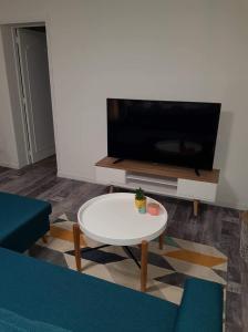 sala de estar con mesa blanca y TV en Iliade, en Rue