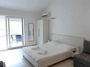a white bedroom with a bed and a chair at Villa Marica in Neum +40 photos