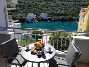 a table on a balcony with a view of the water at Villa Marica in Neum