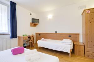a bedroom with two beds and a desk at Affittacamere La Ferrata in San Michele allʼAdige