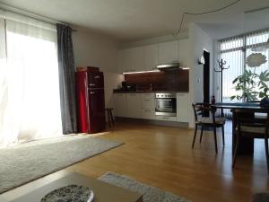 2-Zimmer Apartment Inntalblick في Ampass Unterdorf: مطبخ مع طاولة وثلاجة حمراء