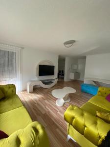 salon z żółtą kanapą i telewizorem w obiekcie O&V Apartment w mieście Waldshut-Tiengen