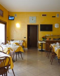 un restaurante con mesas y un reloj en la pared en Hotel Cris en Mestre