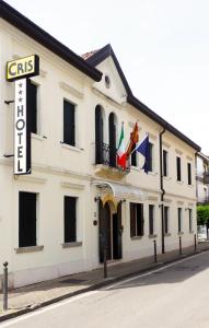 a white building with flags on a street at Hotel Cris in Mestre