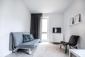 ein Wohnzimmer mit einem Stuhl und einem TV in der Unterkunft Apartament Nadbystrzycka no. 02 in Lublin