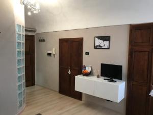 a living room with a television on a white cabinet at Grigio Perla in Cuneo