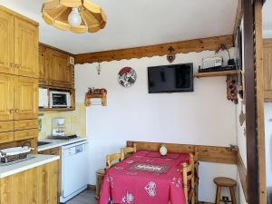 een keuken met een tafel met een rode tafellaken bij Nid aux Menuires in Les Menuires