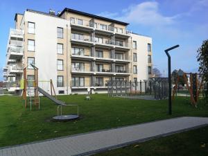 a playground in front of a large building at Coral SPA Apartament Pięć Mórz in Sianozety