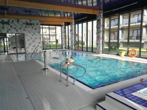 uma grande piscina interior num edifício em Coral SPA Apartament Pięć Mórz em Sianozety