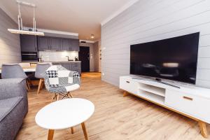 salon z dużym telewizorem z płaskim ekranem w obiekcie FARO Apartamenty Polanki Park z basenami w Kołobrzegu