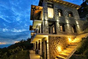 a stone building with lights on the side of it at AlmondHouse Suites with Fireplace - ADULTS ONLY in Arachova