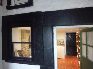 cocina con pared negra y 2 ventanas en The Old Swan walkers cottage en Bath