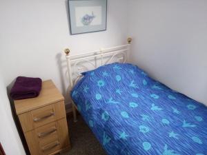 a bedroom with a bed and a wooden night stand at The Old Swan walkers cottage in Bath