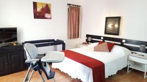 a bedroom with a bed and a desk and a chair at Pedras D'el Rei - Vista Jardim in Tavira