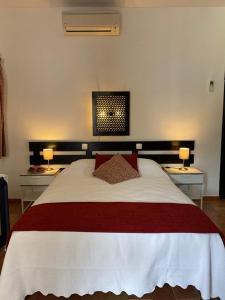 a bedroom with a large bed with two tables at Pedras D'el Rei - Vista Jardim in Tavira