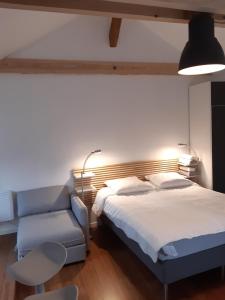 a bedroom with a bed and a blue couch at loft studio avec charme et authenticité in Altkirch
