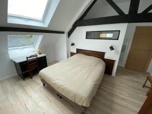 a bedroom with a bed and a desk and a window at À la ferme de Thilloy in Ligny-Thilloy