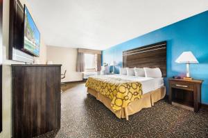 a hotel room with a large bed and a television at Baymont by Wyndham Muncie Near Ball State University in Muncie